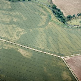 Oblique aerial view centred on the cropmarks of the enclosure and unenclosed settlement with the cropmarks of the rig adjacent, taken from the S.