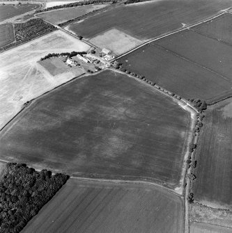 Oblique aerial view centred on the cropmarks of the settlement and field boundaries, with the farmhouse and farmsteading adjacent, taken from the SW.