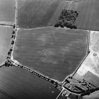 Oblique aerial view centred on the cropmarks of the settlement and field boundaries, with the farmhouse and farmsteading adjacent, taken from the NNE.