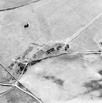 Oblique aerial view centred on the remains of the farmstead with the remains of the tower-house adjacent, taken from the N.