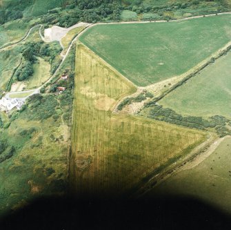 Oblique aerial view centred on the cropmarks of the possible ring ditch and pit with the house adjacent, taken from the S.