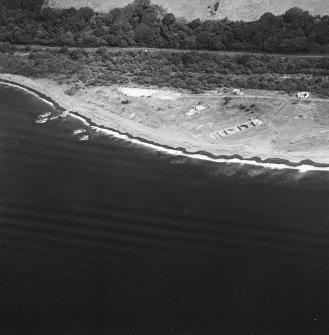 Oblique aerial view centred on the remains of the pile construction yard, scuttled ships, railway yard and railway, taken from the WSW.