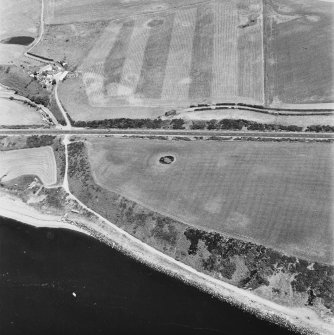 Innermessan, oblique aerial view, taken from the SW, centred on the cropmarks of an enclosure and pits. An enclosure, linear cropmarks and a possible souterrain are shown in the top right half of the photograph.