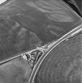 Ballantrae Bridge, oblique aerial view, taken from the E, showing the cropmarks of field boundaries, a possible souterrain and round house, and an area with pits.