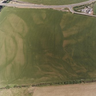 Ballantrae Bridge, oblique aerial view, taken from the SW, centred on the cropmarks of field boundaries and linear cropmarks, and on areas with pits. A possible souterrain and a round house are shown in the upper right-hand corner of the photograph.