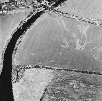 Oblique aerial view centred on the cropmarks of the field boundaries, linear cropmarks, pits, rig and cropmarks, taken from the SW.