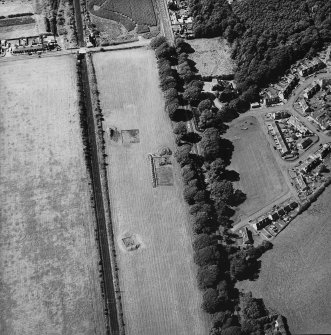 Oblique aerial view centred on the excavation of the remains of the Roman road, quarry pits and the pit-defined cursus, taken from the SE.