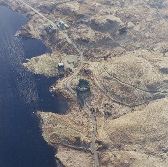 Oblique aerial view centred on the remains of the castle and farmstead, taken from the NE.