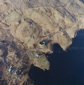 Oblique aerial view centred on the remains of the castle and farmstead, taken from the S.