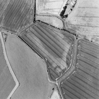 Oblique aerial photograph of Houdston Hill taken from the ENE, centred on the cropmarks of an enclosure and pits.