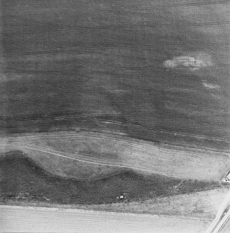 Oblique aerial view centred on the cropmarks of the fort, taken from the WNW.