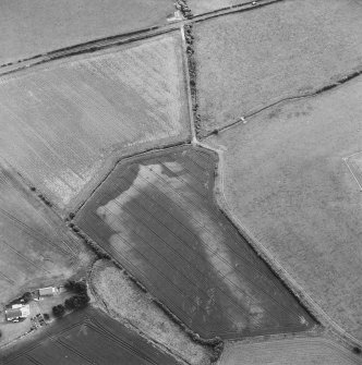 Oblique aerial view centred on the cropmarks of the enclosure and pits, taken from the NW.