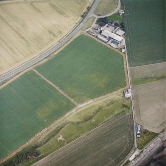 Oblique aerial view centred on the cropmarks of the fort with the farmsteading adjacent, taken from the NNW.