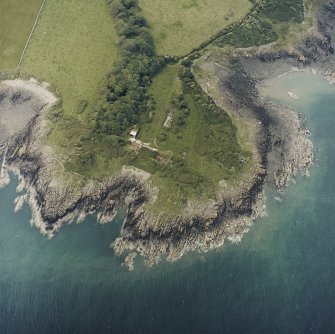 Oblique aerial view centred on the remains of the buildings and promontory fort, taken from the ENE.