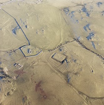 Oblique aerial view centred on the remains of the church, burial ground, homestead moat and building with rig adjacent, taken from the WSW.