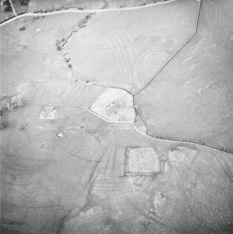 Oblique aerial view centred on the remains of the church, burial ground, homestead moat, building and enclosure with rig adjacent, taken from the SSW.