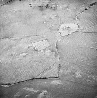 Oblique aerial view centred on the remains of the church, burial ground, homestead moat, building and enclosure with rig adjacent, taken from the SE.