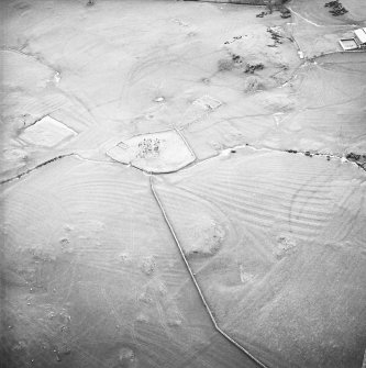 Oblique aerial view centred on the remains of the church, burial ground, homestead moat, building and enclosure with rig adjacent, taken from the ENE.