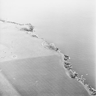 Oblique aerial view looking across the remains of the promontory forts and observation post, taken from the SW.