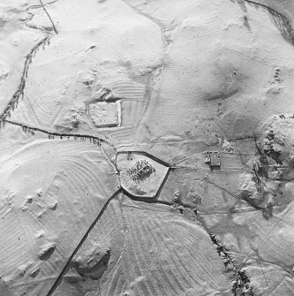 Oblique aerial view centred on the remains of the church, burial ground, homestead moat and building with rig adjacent, taken from the NNW.