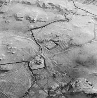 Oblique aerial view centred on the remains of the church, burial ground, homestead moat and building with rig adjacent, taken from the NNW.