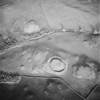 Oblique aerial view centred on the remains of the motte with possible motte adjacent, taken from the SW.