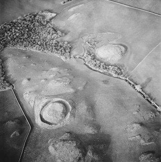 Oblique aerial view centred on the remains of the motte with possible motte adjacent, taken from the SSE.