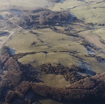Oblique aerial view centred on the remains of field banks and rig with the homestead and the site of Balmae House adjacent, taken from the E.