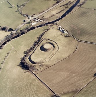 Oblique aerial view centred on the remains of the motte-and-bailey castle, taken from the WNW.