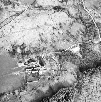 Oblique aerial view centred on the farmsteading and the remains of the township, field-system and castle, taken from the W.