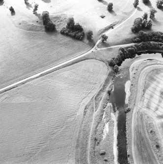 Oblique aerial view of Drumlanrig, taken from the E, centred on linear cropmarks, and the cropmarks of a Roman Temporary Camp and a pit-alignment.  A Roman fort, situated to the E, is visible in the top left-hand corner of the photograph.