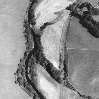 Oblique aerial view showing cropmarks of a Roman fortlet and linear cropmark.