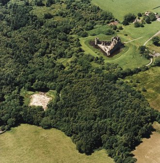 Oblique aerial view centred on the remains of the castle and excavation of the old castle, taken from the E.