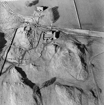 Oblique aerial view centred on the remains of the tower-house, enclosure and farmstead, taken from the S.