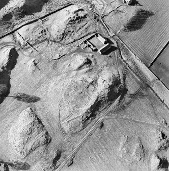 Oblique aerial view centred on the remains of the tower-house, enclosure and farmstead, taken from the SE.
