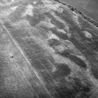 Nethermill School, oblique aerial view, taken from the S, centred on the cropmark of an enclosure.