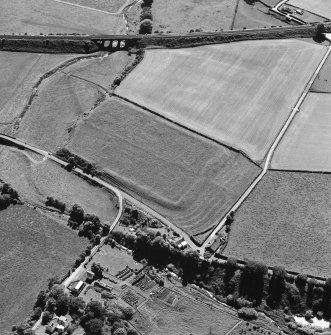 Oblique aerial view of Birrens, taken from the NE, centred on a Roman Fort.  A watermill, situated to the E of the fort is visible in the bottom left-hand corner of the photograph.