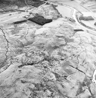 Raeburnfoot, oblique aerial view, taken from the NW, centred on the bank barrow. Raeburnfooot Roman Fort, and enclosures at Kiln Syke, are visible in the top half of the photograph.