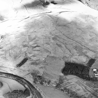 Raeburnfoot, oblique aerial view, taken from the SSW, centred on the bank barrow. Raeburnfoot Roman Fort, and enclosures at Kiln Syke, are visible in the bottom right-hand corner of the photograph.