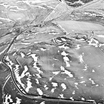 Camp Hill, Bailiehill, oblique aerial view, taken from the NW, centred on a fort and settlement and on an enclosure and cultivation remains. Bailiehill farmstead and an 'enclosure' and cultivation remains are visible in the top half of the photograph.