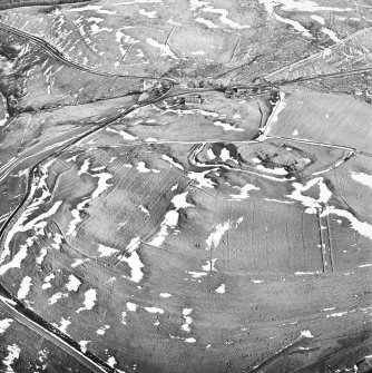 Camp Hill, Bailiehill, oblique aerial view, taken from the NW, centred on a fort and settlement and on an enclosure and cultivation remains. Bailiehill farmstead is visible in the centre top half of the photograph.