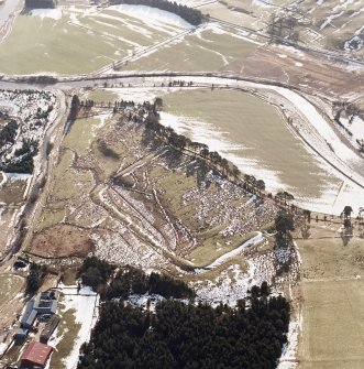 Raeburnfoot, oblique aerial view, taken from the NE, centred on the Roman Fort. Raeburnfoot farmsteading is visible in the bottom left-hand corner of the photograph and Craighaugh settlement and platform-building is shown in the top right-hand corner.