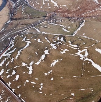 Camp Hill, Bailiehill, oblique aerial view, taken from the NW, centred on a fort and settlement and on an enclosure and cultivation remains. Bailiehill farmstead is visible in the centre top half of the photograph.