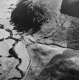 Oblique aerial view of Fiddleton centred on the remains of two scooped settlements, cultivation terraces and a cottage, taken from the NNE.