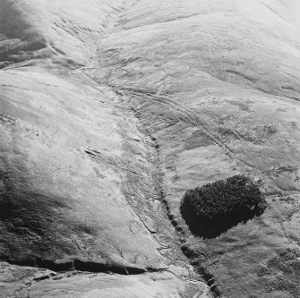 Oblique aerial view of Wrangway Burn centred on the remains of hollow-ways, a road, a possible Roman road, a linear earthwork and a possible Roman watch tower, taken from the NE.