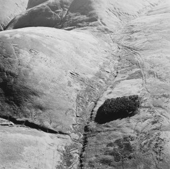 Oblique aerial view of Wrangway Burn centred on the remains of hollow-ways, a road, a possible Roman road, a linear earthwork and a possible Roman watch tower, taken from the NNE.