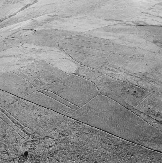 Oblique aerial view of Side centred on the remains of boundary ditches, farmstead, sheep stell, field-system, rig and lazy beds with a farmstead, field-system, rig and boundary banks adjacent and a fort and palisaded enclosure in the background, taken from the S.