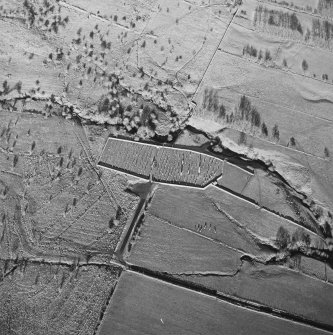 Oblique aerial view of Ettleton Sike centred on a burial ground with a building, field-system, rig and sheepfold and hut, field-system, rig and enclosure adjacent, taken from the S.