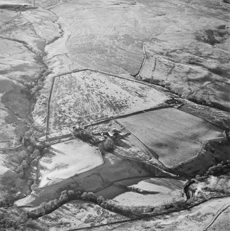 Oblique aerial view of Blackburn centred on the remains of a boundary bank with the remains of a lade and a settlement and possible buildings adjacent, taken from the NE.