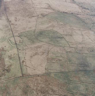 Oblique aerial view centred on the remains of the fort and palisaded enclosure, field-system, rig and boundary banks with enclosures, lazy beds, boundary ditches, field-system and rig adjacent, taken from the SW.